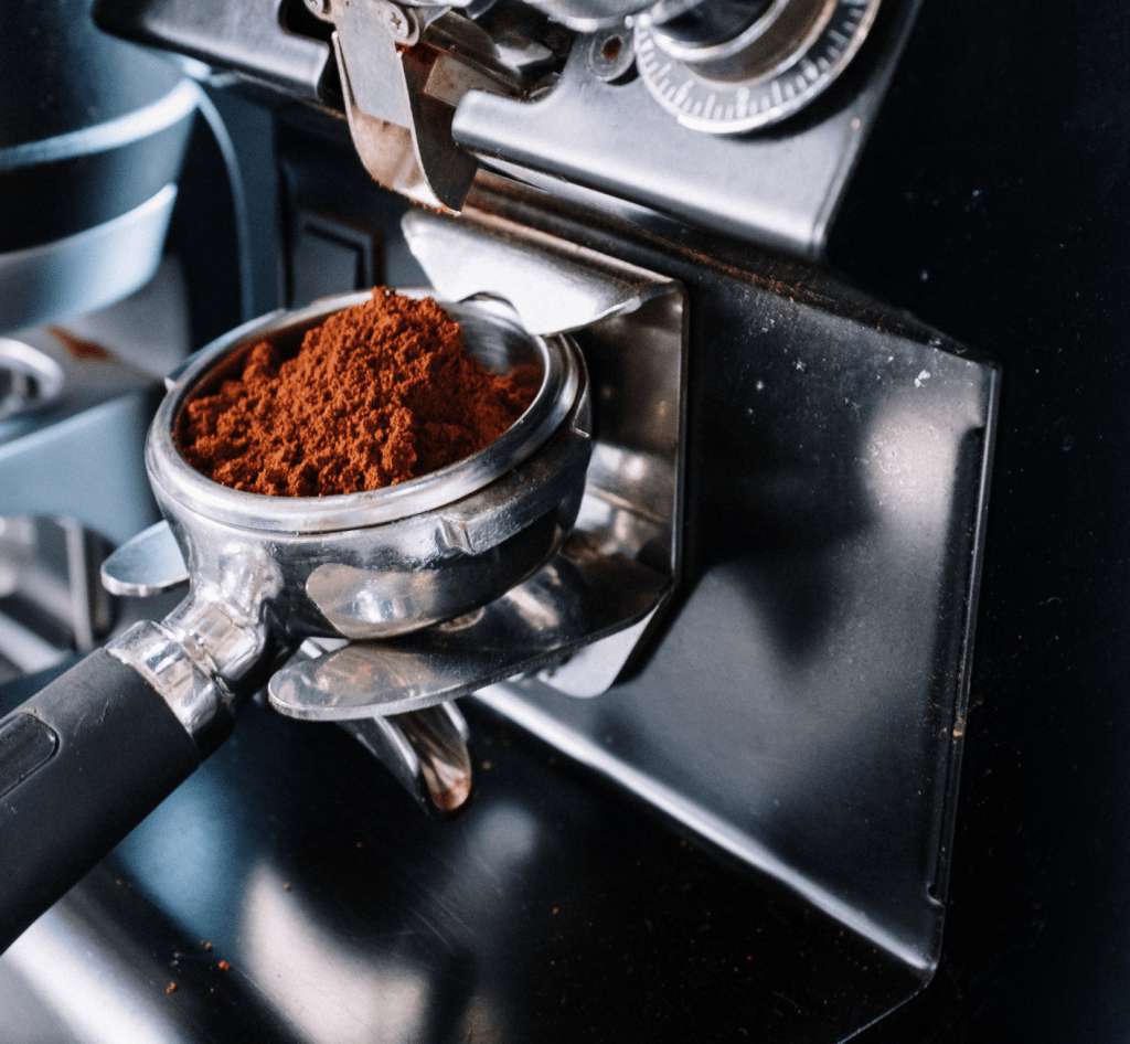 páka s mletou kávou v držáku u espresso mlýnku