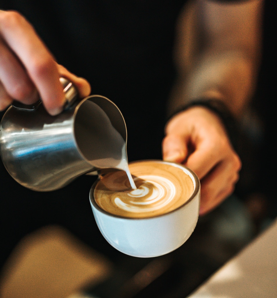 tvorba latte artu do cappuccina v bílém šálku