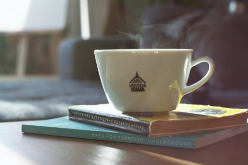 Pracovníci pijící kávu na obchodním setkání, co ilustruje vliv kávy na mozek a pracovní efektivitu.