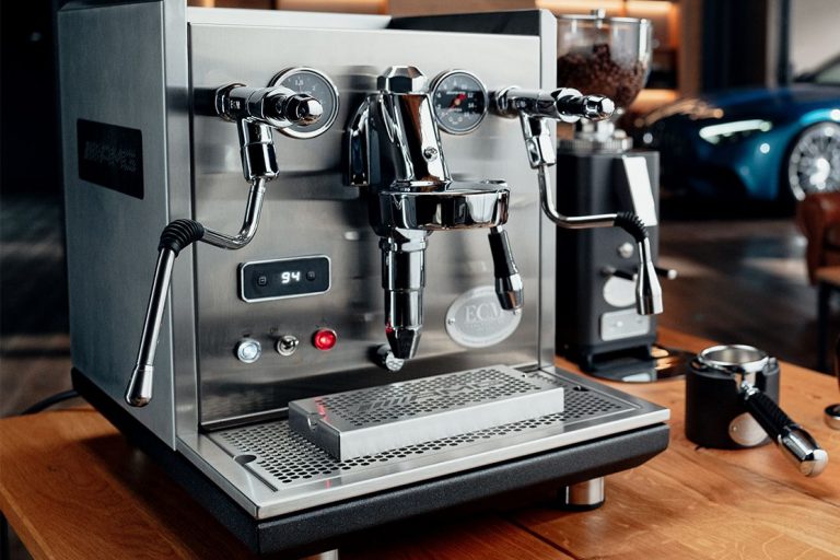 Kávovar ECM Synchronika AMG No.1 s broušeným nerezovým tělem na stole.